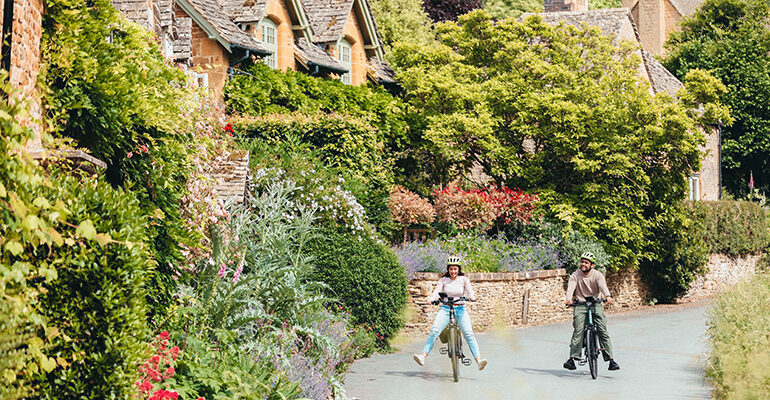 Un couple de cyclistes se promène en campagne des Cotswolds