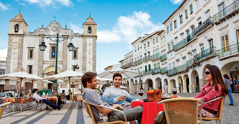 Un groupe d'amis se restaure sur une place centrale de ville blanche