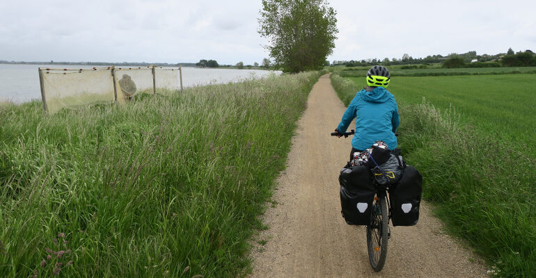 Un cycliste roule sur une piste de campagne