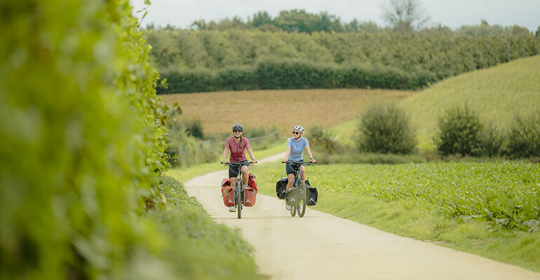Deux cycliste roule sur le chemin de halage au milieu de la verdure