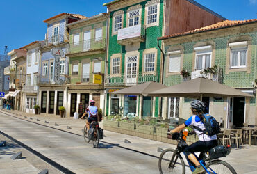 Couple de cycliste traversant une rue colorée