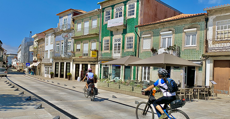 Couple de cycliste traversant une rue colorée