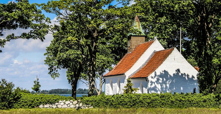 Un petite église blanche au toit rouge en campagne