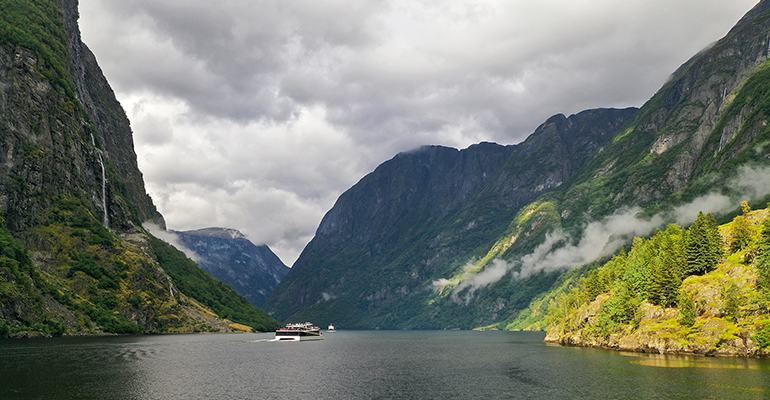 Un bateau traversant un fjord entouré de montagnes