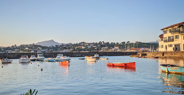 Des petites barques colorée sur un port au coucher de soleil