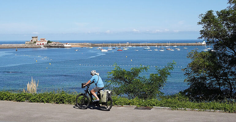Un cyclise roule le long de la côte basque