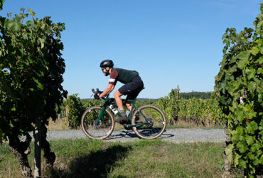 Un cycliste gravel roule au milieu des vignes