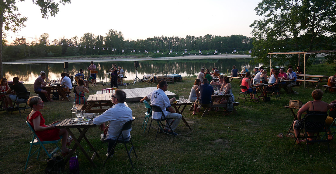 Des personne sont assise dans une ginguette extérieur au bord de la loire