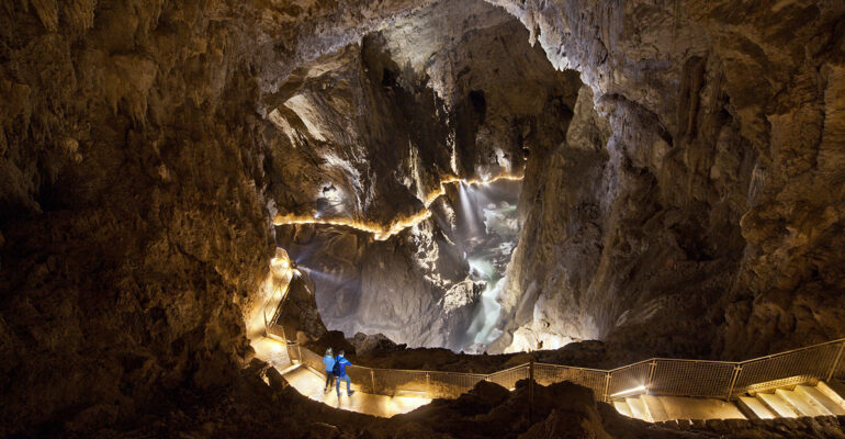Un couple visite l'intérieur de la Grotte de Skocjan