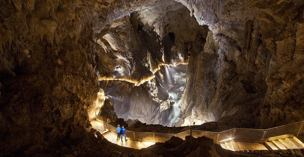 Un couple visite l'intérieur de la Grotte de Skocjan