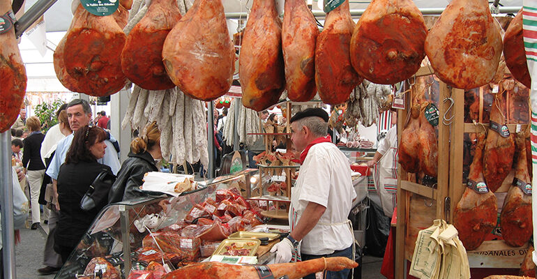 Une étale de marché remplie de jambon de Bayonne