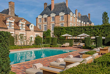 Un château transformé en hôtel avec sa piscine et son espace détente extérieur