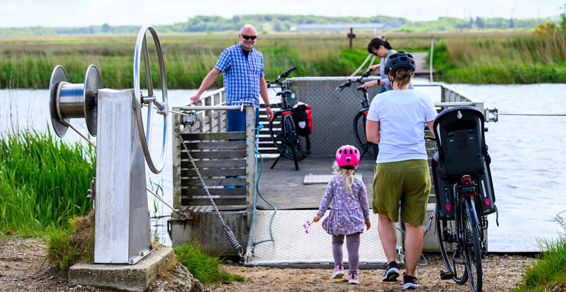 Une famille de cycliste monte sur un bateau avec leurs velos