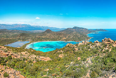 Corse, vue panoramique sur une baie aux eaux turquoises entourée de montagnes