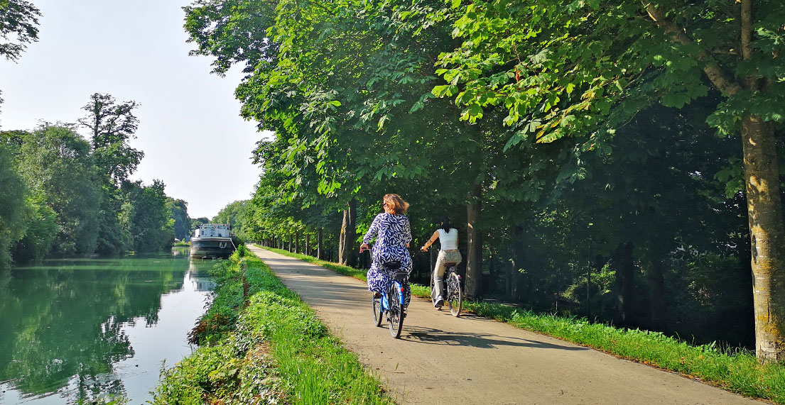 Deux cyclistes se promènent le long d'un canal