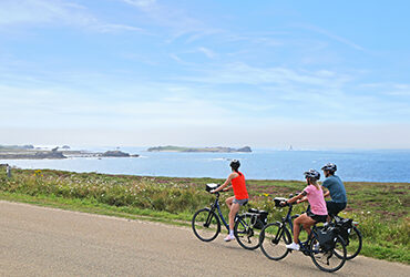 Un groupe de cyclistes roule le long du littoral breton fleuri
