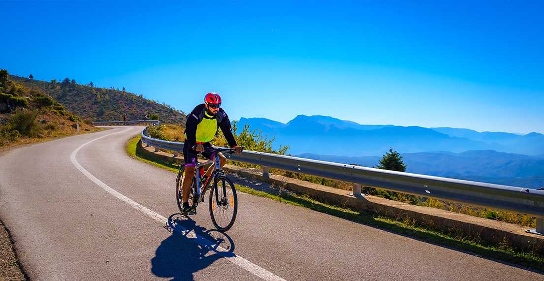 Un cycliste roule sur une route de montagne