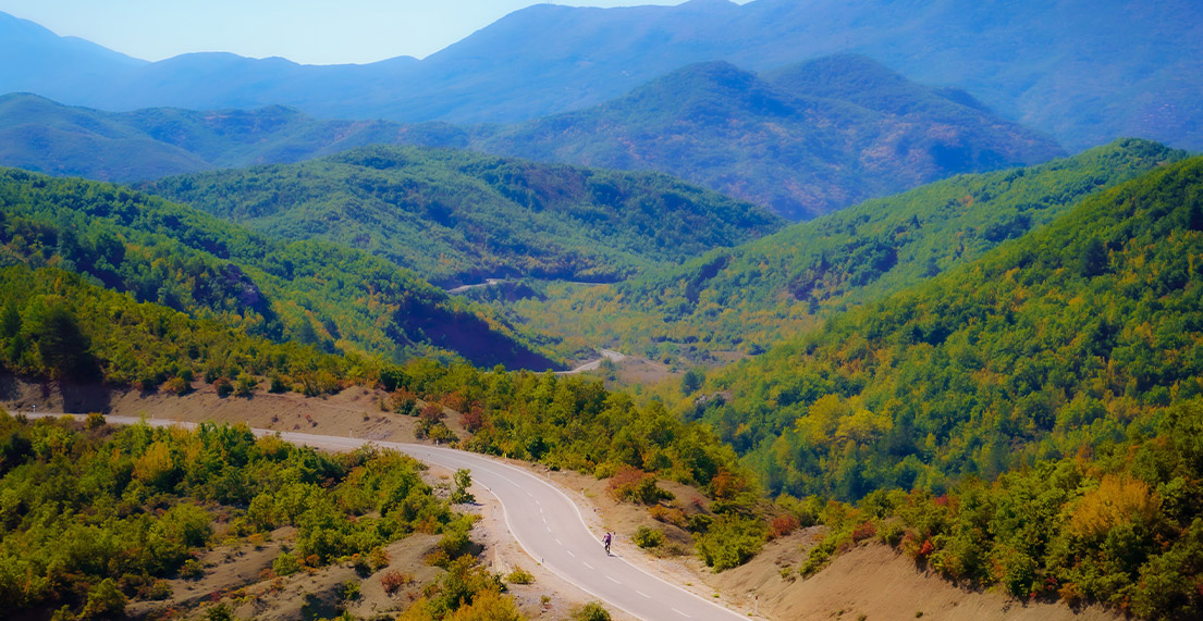 Un cycliste roule sur une route de montagne