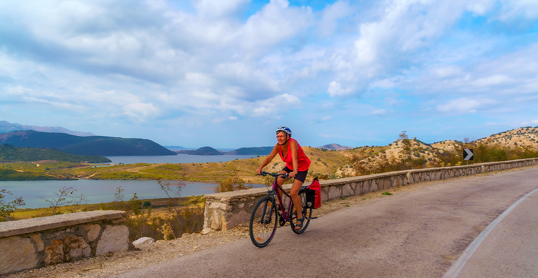 Une cycliste roule le long d'une route cotiere