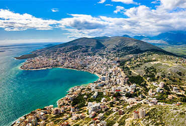 Vue panoramique sur une ville perchées à flanc de montagne et qui se jete dans les eaux turquoises de la Méditerranée