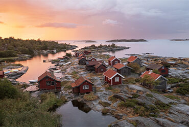 Des cabanes typiques de la scandinavie sur un fjord au soleil de minuit