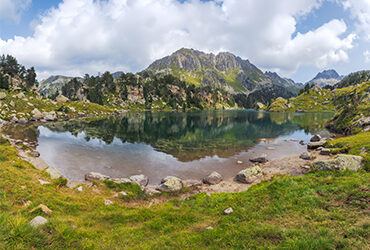 Une chaine de montagnes se reflete dans les eaux d'un petit lac